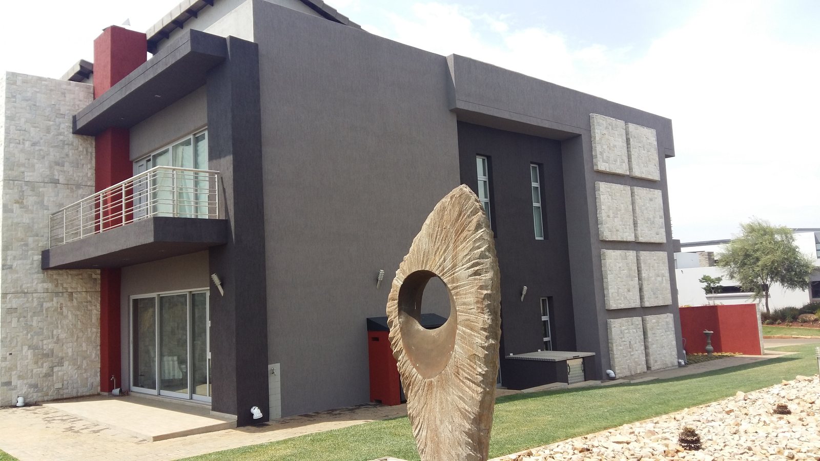 Completed modern home with dark coating and red accents